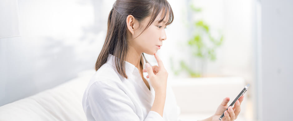 スマホを真剣な表情で見つめる女性