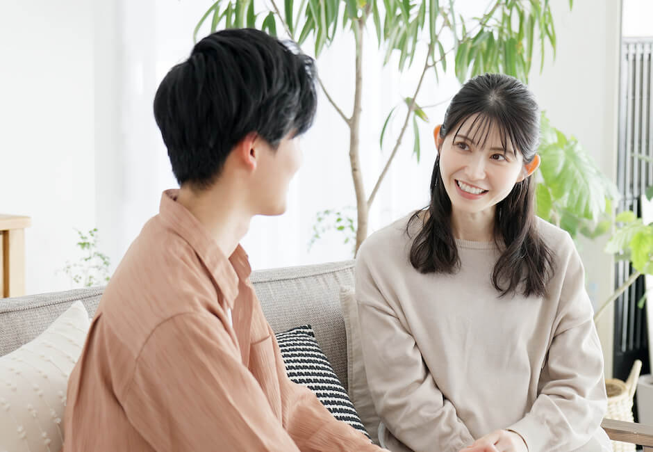 リビングのソファで向かい合って談笑する男女